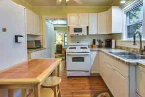 cocina con electrodomésticos blancos y mesa de madera en Turtle Cove Bay Beach House about 13 Mi to Buffalo!, en Lake View