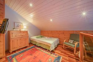 1 dormitorio con 1 cama y 1 silla en una habitación en Levillas Sävelpolku 12B, en Levi
