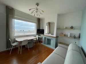 ein Wohnzimmer mit Sofa und Tisch in der Unterkunft Appartement la capitainerie in Cayeux-sur-Mer