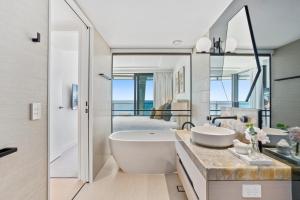 黄金海岸Jewel Beachfront Residences的带大浴缸和水槽的浴室