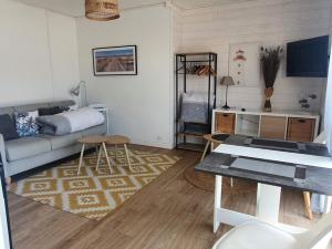 un soggiorno con un divano e un tavolo di Studio, proche du Touquet, tout équipé à 100m de la plage a Stella-Plage