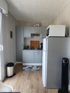 una piccola cucina con frigorifero bianco e pavimenti in legno di Studio, proche du Touquet, tout équipé à 100m de la plage a Stella-Plage Altre 8 foto