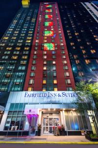 a tall red building with a lit up facade at Fairfield Inn & Suites By Marriott New York Manhattan/Times Square in New York