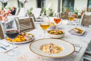 una tavola con piatti di cibo e bicchieri di vino di Summer Dream a Rethymno