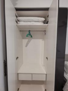 um pequeno armário branco com uma cama em Cozy Studio 3pax, Menara Sentral by VL HOME em Bukit Mertajam