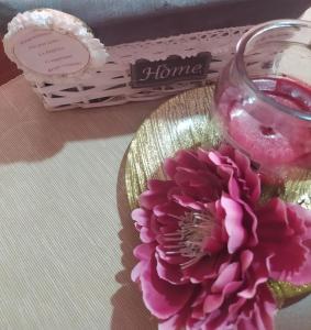 un plato de vidrio con una flor rosa y una vela en La Peonia, en Vitorchiano