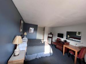 a bedroom with a bed and a desk and a tv at BIGGS NU-VU MOTEL in Biggs Junction