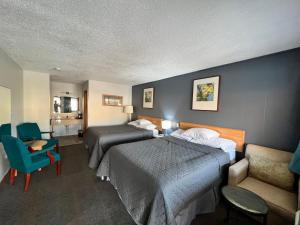 um quarto de hotel com duas camas e uma cadeira em BIGGS NU-VU MOTEL em Biggs Junction