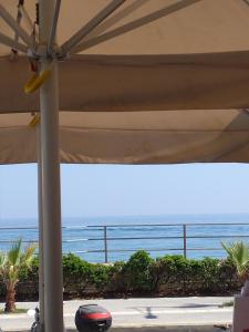 a view of the ocean from under an umbrella at Anastasios Luxury Apartment Sea View in Rethymno Town