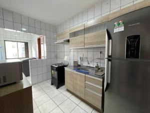 a kitchen with a stainless steel refrigerator and a sink at Aconchegante apartamento no centro em Balneário Camboriú SC in Balneário Camboriú