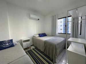 a small bedroom with two beds and a window at Aconchegante apartamento no centro em Balneário Camboriú SC in Balneário Camboriú