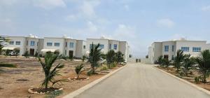 uma estrada em frente a uma fila de edifícios brancos em Luxury Garden Villas Complex em Salalah