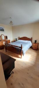a bedroom with a large wooden bed in a room at Biddys cottage in Donegal