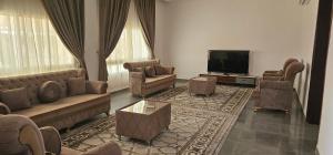 Il comprend un salon avec des canapés et une télévision à écran plat. dans l'établissement Luxury Garden Villas Complex, à Salalah