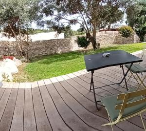 una mesa y una silla en el patio en Chambre cosy en Bonifacio