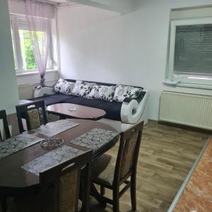 sala de estar con mesa y sofá en Vila Slavonija, en Vrnjci