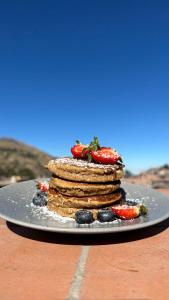 a stack of pancakes with strawberries and blueberries on a plate at Hotel Sol de Canta in Canta +8 photos