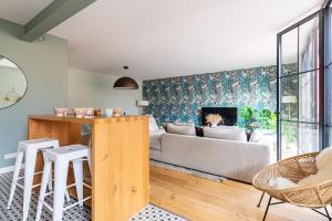 een woonkamer met een bank en een tafel bij LE BOSTON - Hypercentre - 150 M 2- 7 Guest in Dijon