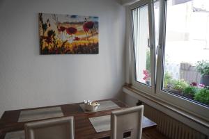 een eetkamer met een tafel en een raam bij Bright, spacious apartment with a lovely terrace in the heart of Aachen in Aken