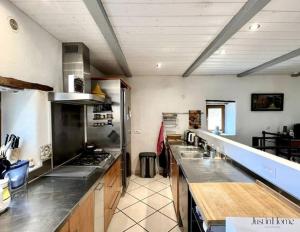 a large kitchen with stainless steel appliances and counters at Mas en pierre de 300m2, piscine, terrasse, 4 chbre in Sainte Anastasie - Aubarne