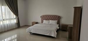 a bedroom with a bed and a large window at Luxury Garden Villas Complex in Salalah