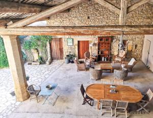 a living room with a wooden table and chairs at Mas en pierre de 300m2, piscine, terrasse, 4 chbre in Sainte Anastasie - Aubarne