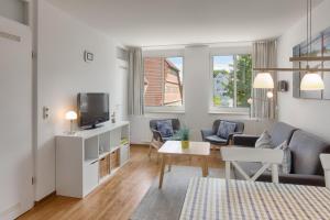 uma sala de estar com um sofá e uma televisão em Apartment 7 em Heiligenhafen