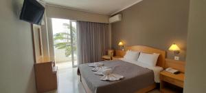 een hotelkamer met een bed met handdoeken erop bij Hotel Serenity Tolo in Tolo