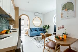 a kitchen and living room with a blue couch at Crescendo Boutique Studio - STAY 24h in Hanoi