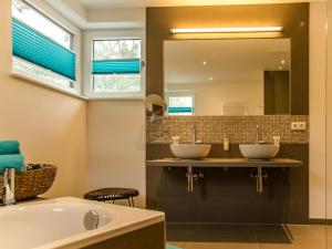 a bathroom with three sinks and a tub and a mirror at 5* Strandhaus in Karlshagen in Ostseebad Karlshagen