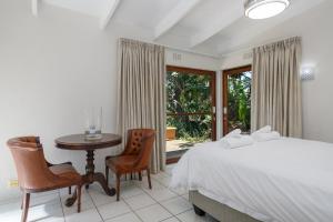 um quarto com uma cama, uma mesa e cadeiras em San Lameer Villa 1901 - 3 Bedroom Superior - 6 pax - San Lameer Rental Agency em Southbroom