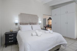 a bedroom with a large white bed with white cabinets at San Lameer Villa 1901 - 3 Bedroom Superior - 6 pax - San Lameer Rental Agency in Southbroom