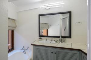 a bathroom with a sink and a tub and a mirror at San Lameer Villa 1901 - 3 Bedroom Superior - 6 pax - San Lameer Rental Agency in Southbroom