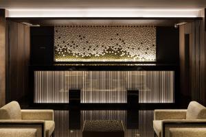 a lobby with two chairs and a large screen at the b namba-kuromon in Osaka