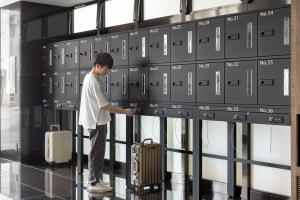 a man standing in an airport with his luggage at the b namba-kuromon in Osaka
