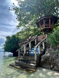 a tree house on the side of a rock in the water at White Bada Guesthouse in Siquijor
