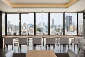 a restaurant with tables and chairs and a view of the city at the b namba-kuromon in Osaka