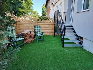 a backyard with green grass and stairs and chairs at ablotu - 2-8 person, parking,garden in Świnoujście
