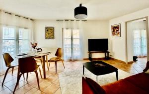 ein Wohnzimmer mit einem Tisch und einem TV in der Unterkunft Le Sébastopol -Très Bel appartement en plein centre de Beziers-Wifi in Béziers