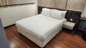 a bed with white sheets and pillows in a room at 2 Rooms Duplex, I Suite i-City, Up to 4 Pax, Free Wi-Fi, Fully Furnish in Shah Alam +22 photos