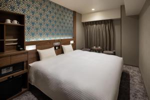 a hotel room with a large bed and a tv at the b namba-kuromon in Osaka