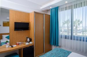 a hotel room with a bed and a tv and a window at My Marin Otel in Turgutreis