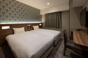 a hotel room with a large bed and a desk at the b namba-kuromon in Osaka
