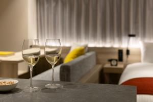 two wine glasses sitting on a table in a hotel room at the b namba-kuromon in Osaka
