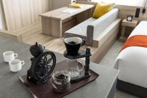 a table with a cup of coffee on it in a bedroom at the b namba-kuromon in Osaka