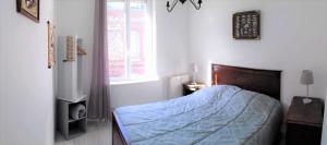 sypialnia z łóżkiem z niebieską kołdrą i oknem w obiekcie Gîte Escale en vue - 3 Chambres - 150 m de la plage - w mieście Fécamp