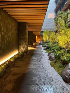 a walkway under a building with a bridge at Dusit Thani Kyoto in Kyoto