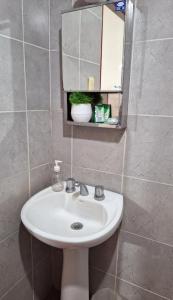 a bathroom with a white sink and a mirror at Departamento Vela Céntrico in Concepción