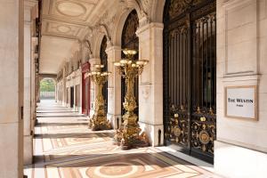 a hallway of a building with gold columns and gates at The Westin Paris - Vendôme in Paris