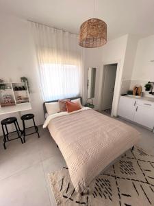 a white bedroom with a large bed in a room at ארץ מדבר - יחידת אירוח בבאר אורה in Beʼer Ora